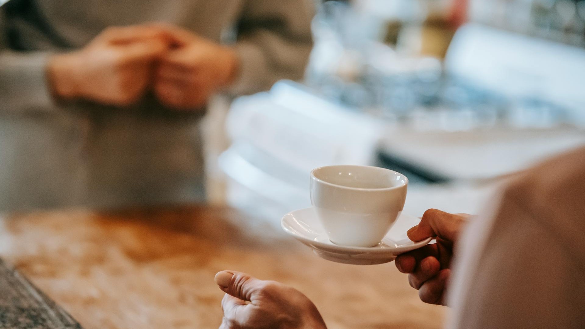Anonymous couple drinking coffee in kitchen